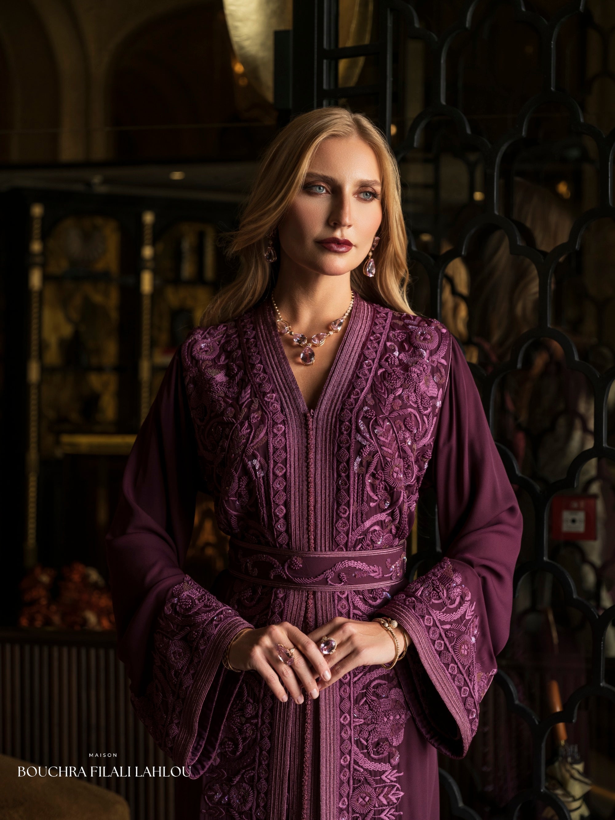 Deep violet Moroccan caftan detail with ornate embroidery and fluid wide sleeves